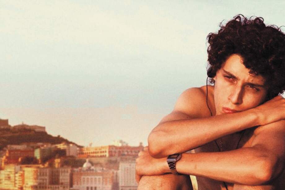 Imagen de la película italiana "Fue la mano de Dios" con Filippo Scotti, el protagonista que encarna a Fabietto Schisa, en primer plano y con la ciudad de Nápoles detrás. / Cortesía: Netflix