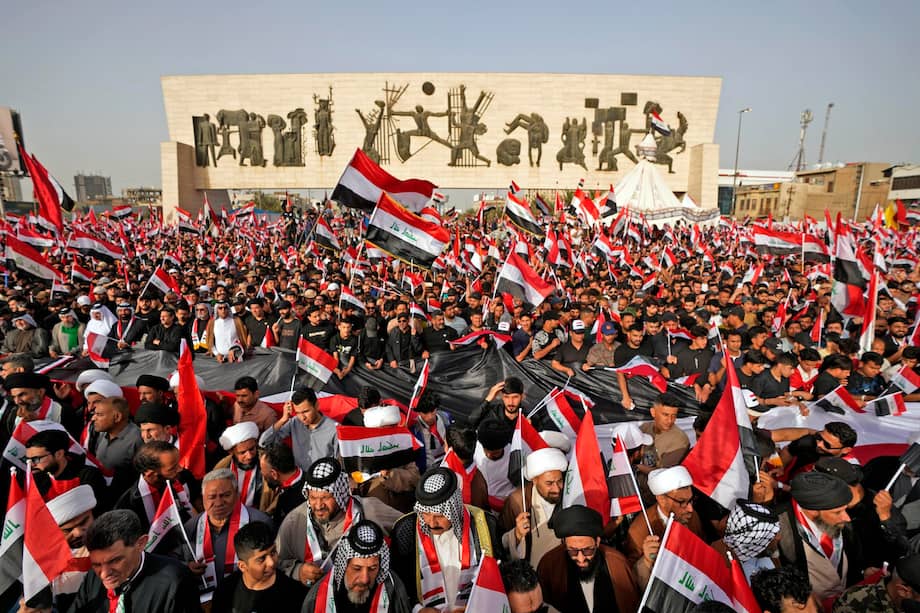 Seguidores del clérigo chií iraquí Muqtada al‑Sadr ondean banderas nacionales de Iraq durante una protesta contra los ataques conjuntos de Estados Unidos e Israel sobre Irán, este sábado en la Plaza Tahrir de Bagdad (Irak).