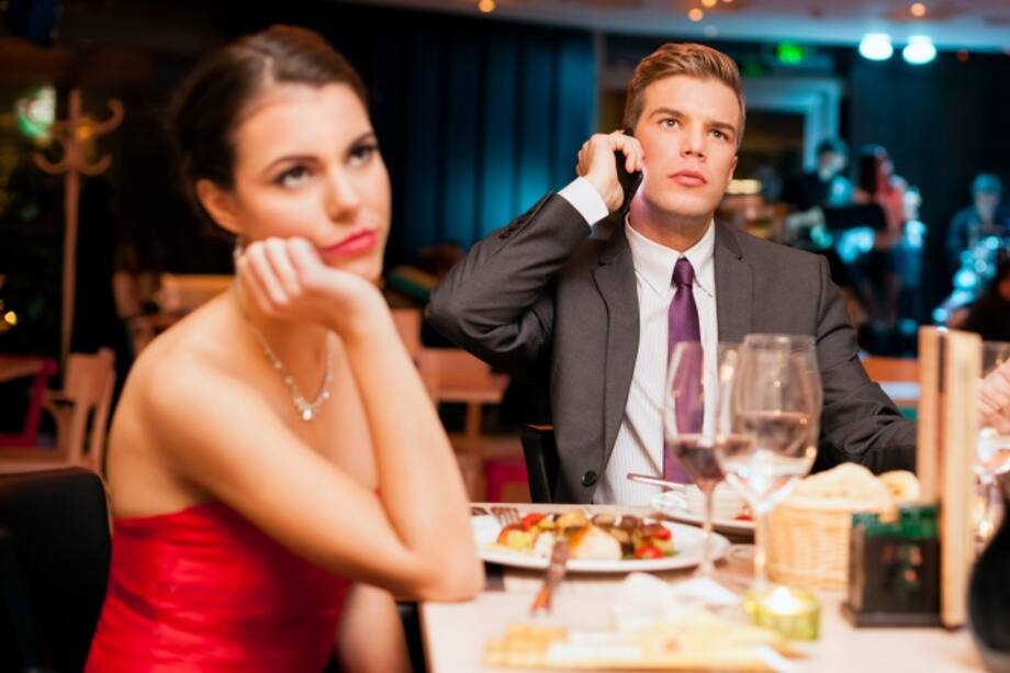 Mujer aburrida por ver a su pareja hablando por celular