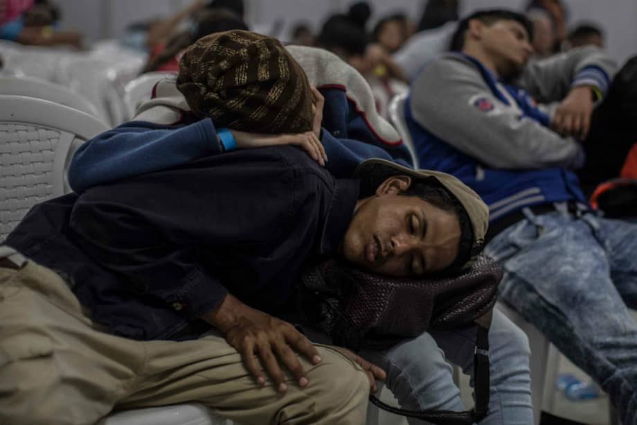 Migrantes venezolanos en Medellín descansan mientras esperan la segunda Feria del trabajo para venezolanos en la ciudad.
/ AFP