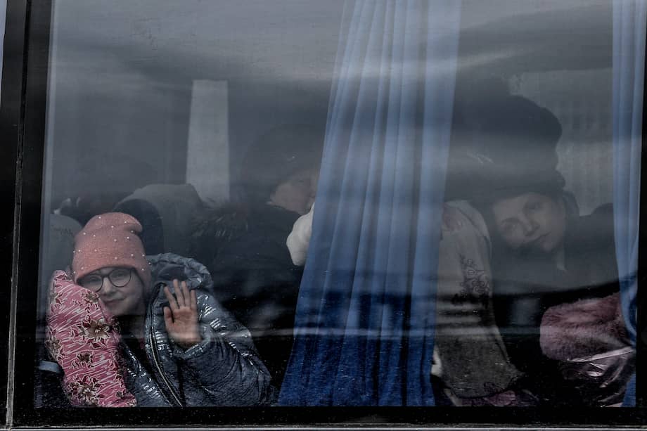 Una niña saluda desde un autobús en el que ha llegado a Zaporiyia, en abril de 2022. Esta ciudad del centro este de Ucrania es la ciudad a donde llegan la mayor parte de personas que huyen de Mariúpol y las localidades cercanas controladas por el ejercito ruso. EFE/Manuel Bruque