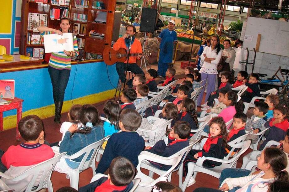 Varios niños asisten a los talleres de lectura en las plazas de mercado de Bogotá.