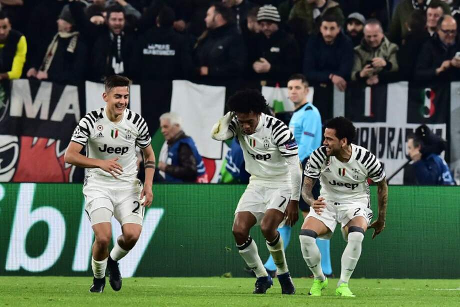 El colombiano Juan Guillermo Cuadrado (c) celebra el tanto que anotó el argentino Paulo Dybala (i), que le dio el triunfo este martes a Juventus. / AFP