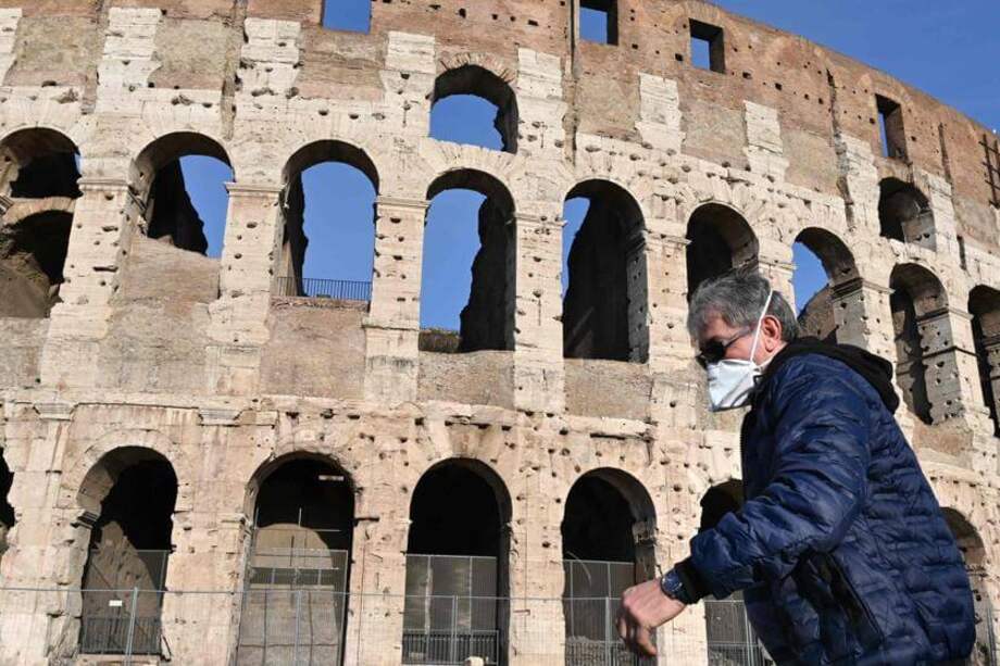 El coliseo romano, la soledad y un hombre con mascarilla. Imágenes de la crisis del Coronavirus. / Afp