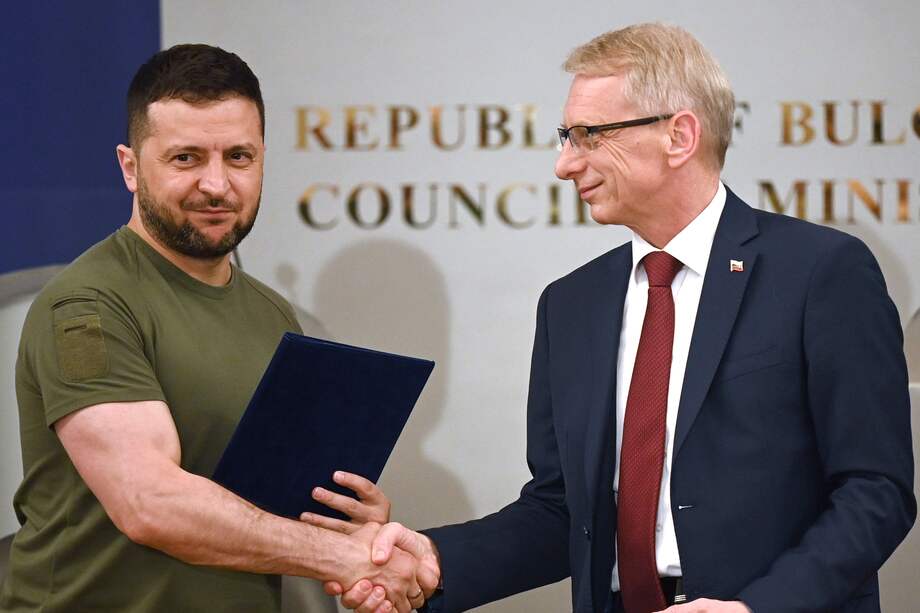 El primer ministro de Bulgaria, Nikolai Denkov, y el presidente de Ucrania, Volodimir Zelenski, se dan la mano tras firmar un acuerdo para una mayor cooperación en materia de defensa.