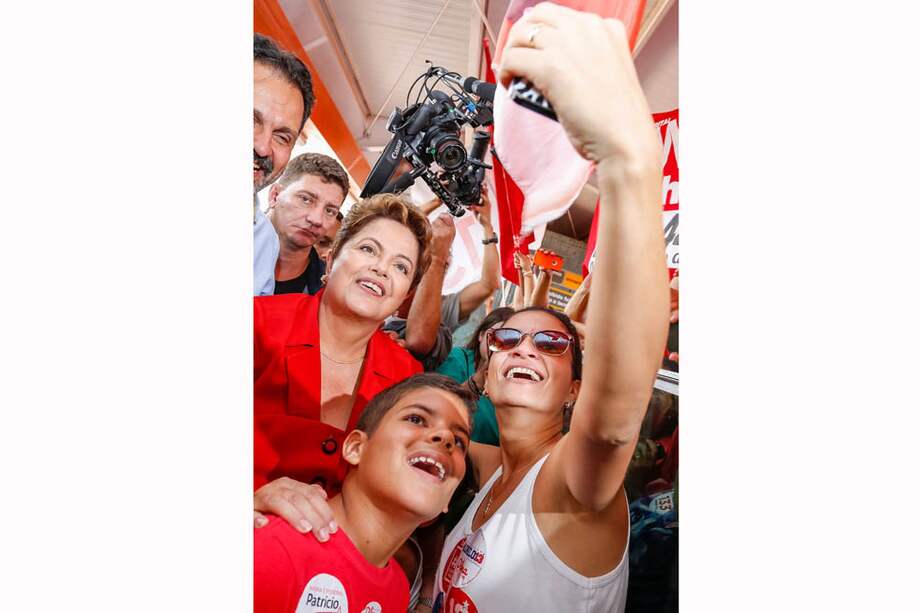 La presidenta Dilma Rousseff se toma una fotografía con una seguidora en Brasilia. / AFP