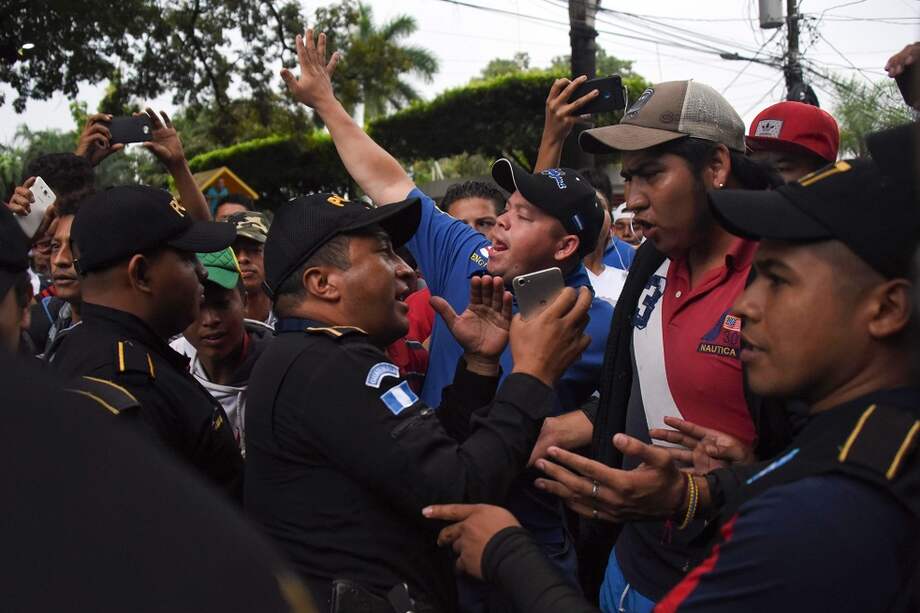 Migrandes de Honduras en caravana hacia Estados Unidos con la Policía de Guatemala. / AFP