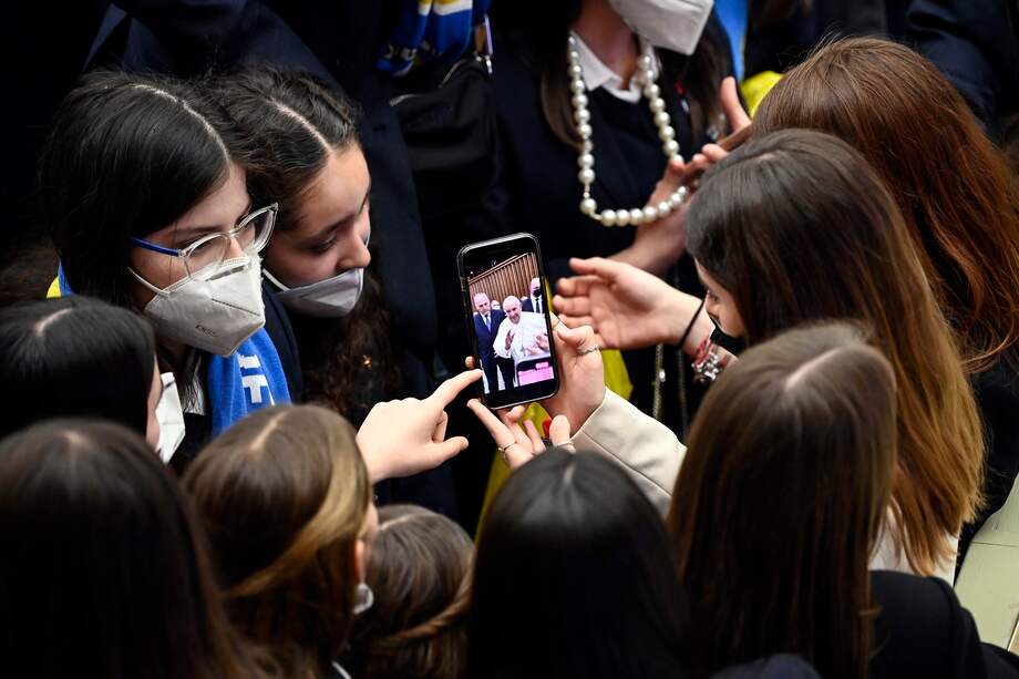 Imagen de referencia. Jóvenes fieles miran un teléfono durante una audiencia general semanal del papa Francisco.