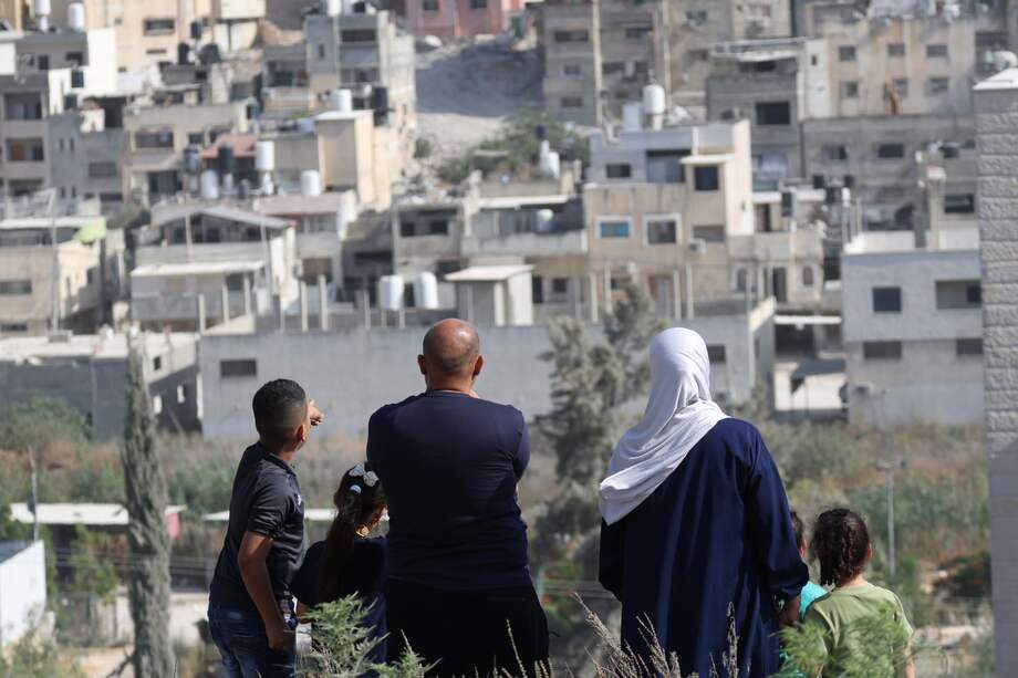 Personas desplazadas del campo de refugiados de Nur Shams observan cómo las excavadoras del ejército israelí demuelen edificios durante una operación militar israelí en el campo de refugiados de Nur Shams, cerca de la ciudad cisjordana de Tulkarem.