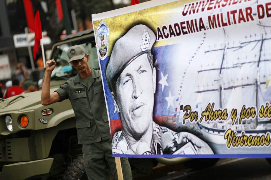 Un soldado participa en el desfile militar del 4F llevando una pancarta de apoyo a Hugo Chávez. / EFE