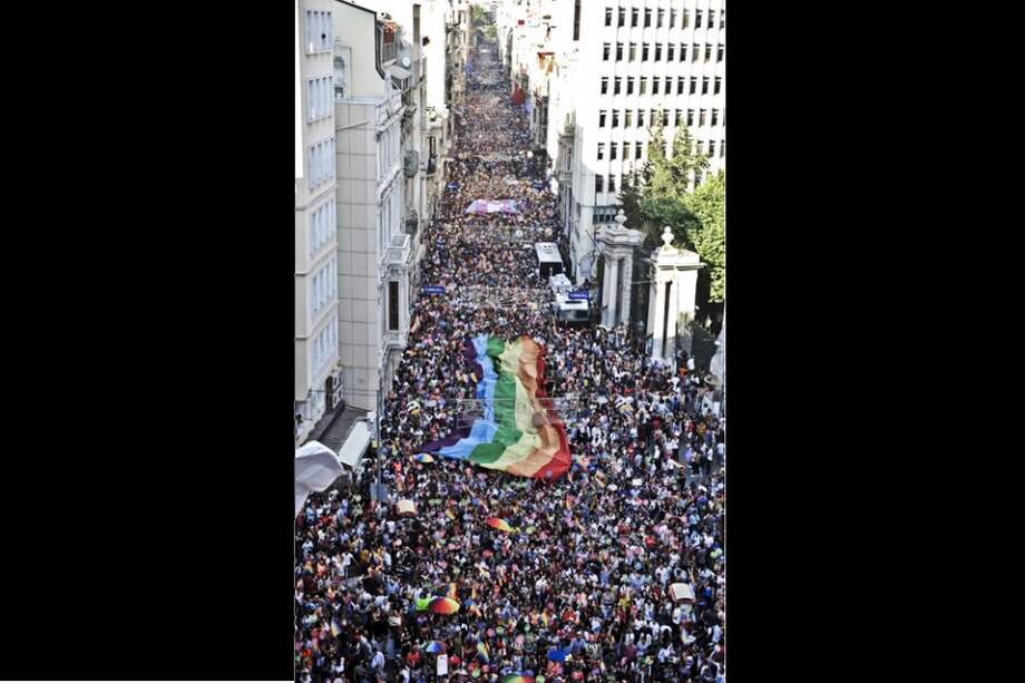 Las personas sostienen una bandera gigante de arcoíris durante la marcha del orgullo gay en la calle Istiklal de Estambul, un corredor principal, como parte de la semana del orgullo trans 2014 organizado por la organización LGTBI.
