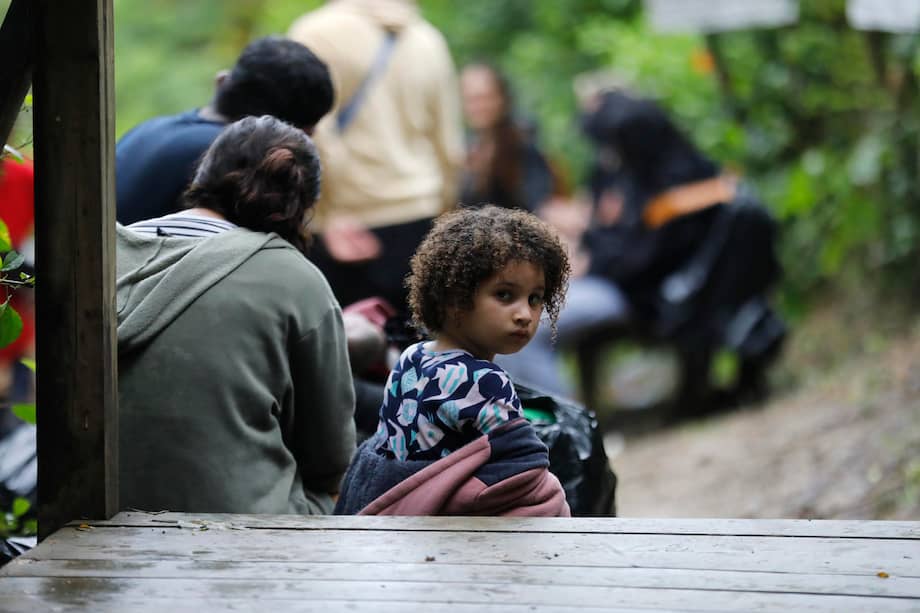 Una niña descansa junto a su familia en un recorrido de migrantes en Sapzurro (Colombia). Suben a las lanchas en grupos de doce, cargando niños en brazos y bolsas negras con sus pertenencias, en un rincón del Caribe colombiano, entre la selva y un mar turquesa de postal, que marca una de las puertas de entrada a Sudamérica, la tierra que abandonaron y a la que ahora se ven forzados a regresar.
