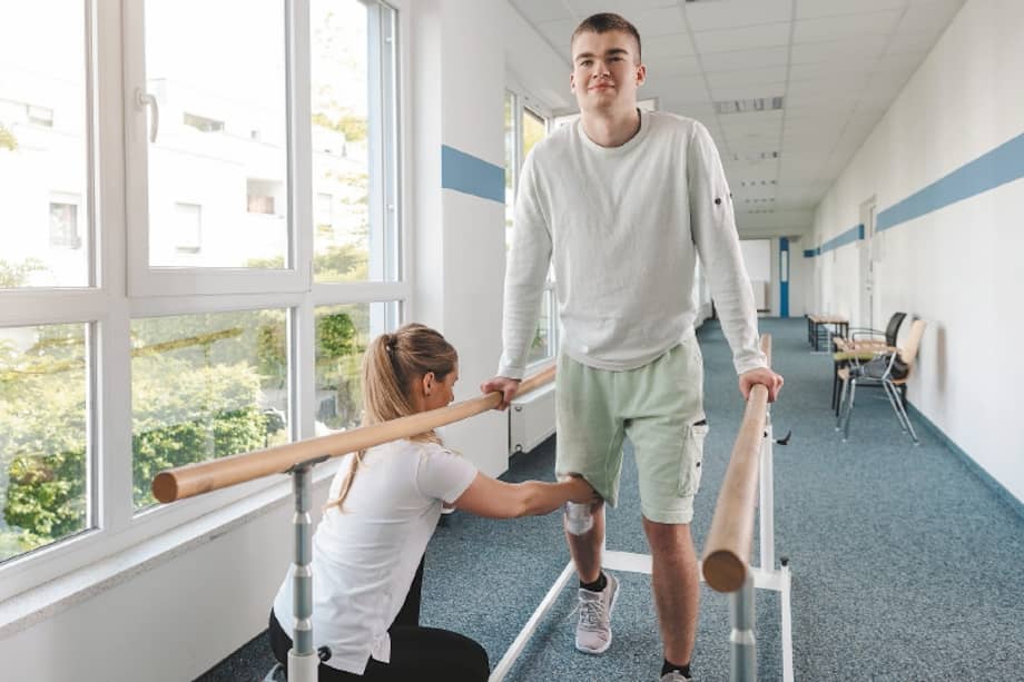 Young man in walking rehabilitation course after a sport injury on his knee