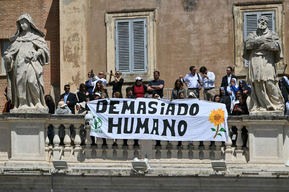 "Demasiado humano" fue el mensaje que escogió este grupo para estampar en su pancarta que acompañó los funerales del papa Francisco. (Photo by Alberto PIZZOLI / AFP)