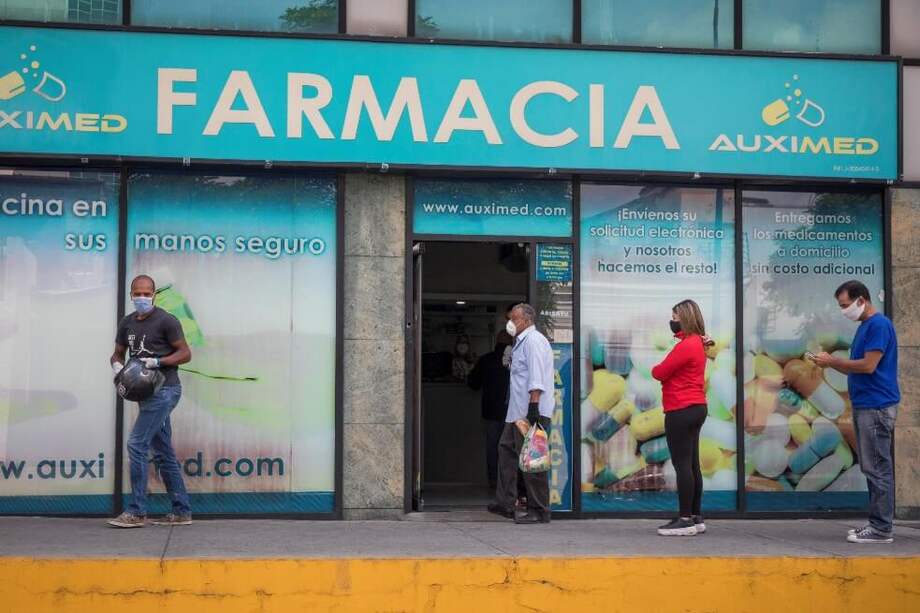Personas con tapabocas hacen fila este miércoles para abastecerse de medicamentos y productos de higiene personal en una farmacia de Caracas (Venezuela). / EFE