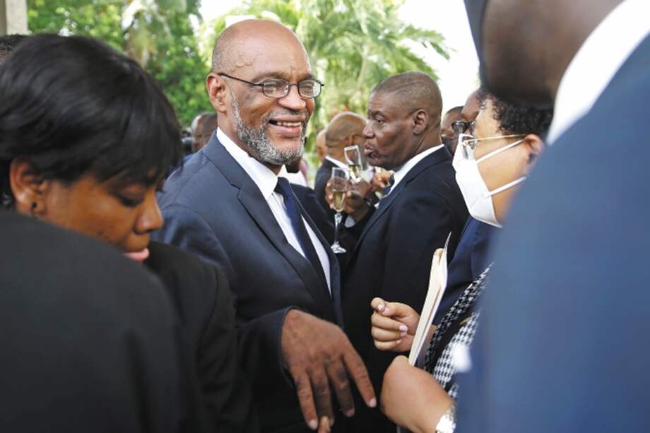 New Prime Minister Ariel Henry, center, talks to members of his cabinet after his appointment in Port-au-Prince, Haiti, Tuesday, July 20, 2021, weeks after the assassination of President Jovenel Moise at his home. (AP Photo/Joseph Odelyn)
