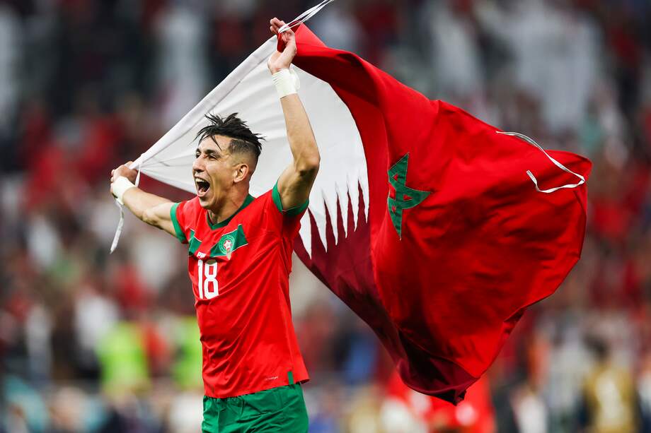 Jawad El Yamiq, jugador de Marruecos, celebra con la bandera de su país la clasificación a semifinales de Catar luego de vencer a Portugal.