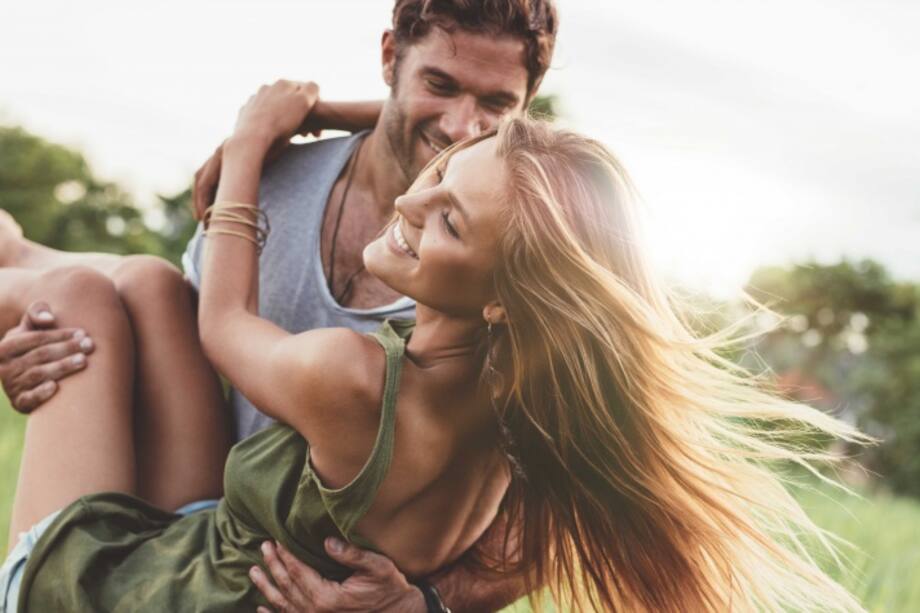 Hombre levantando en sus brazos a su pareja