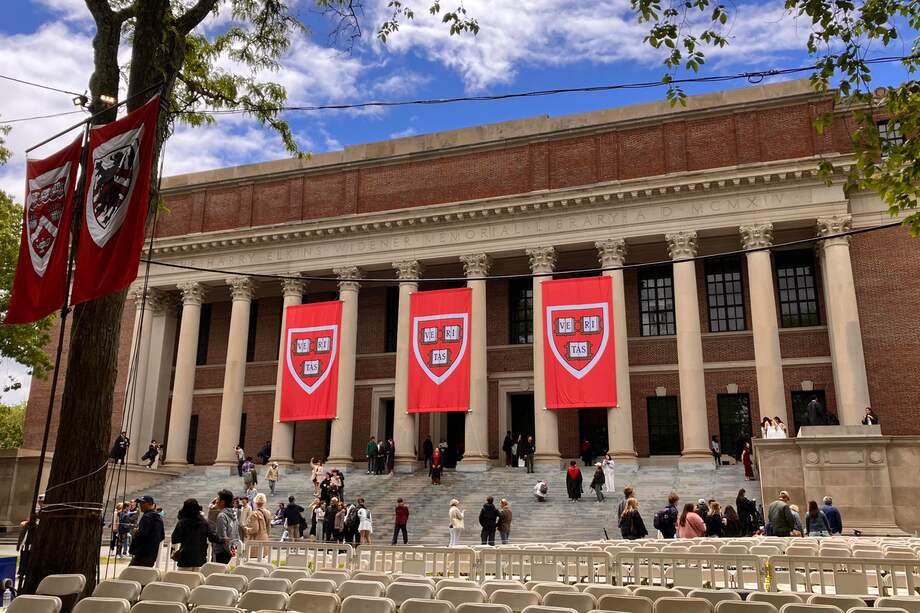 Unas personas caminan frente a la biblioteca de la Universidad de Harvard.