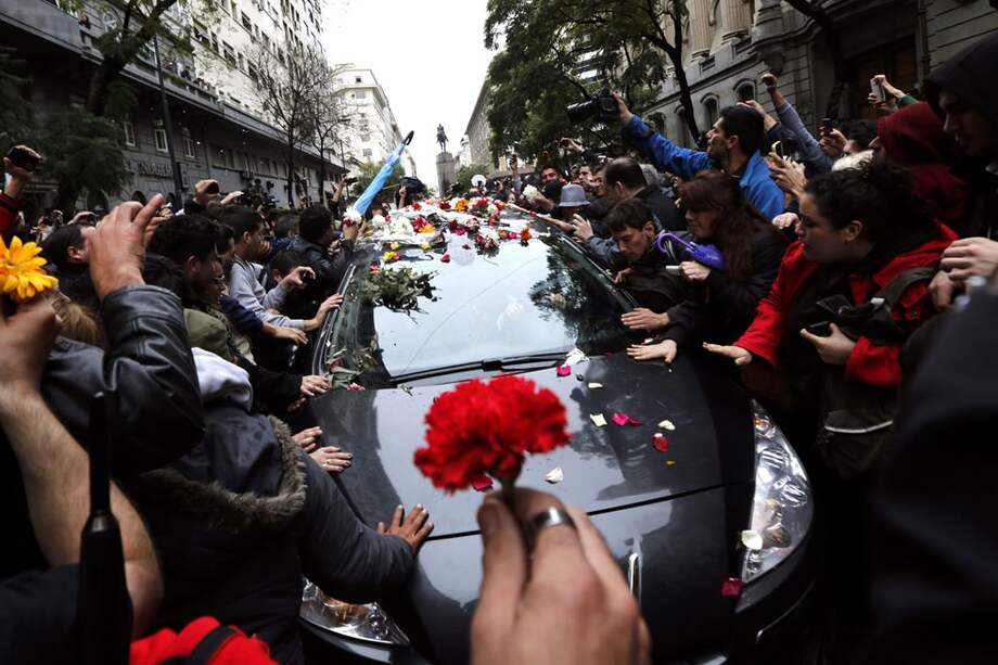 Fanáticos rodean el vehículo que llevaba los restos de Gustavo Cerati. / Reuters
