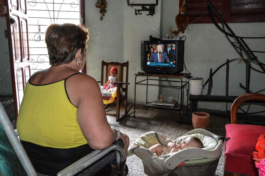 Una cubana ve por televisión un discurso de Trump sobre Cuba. / AFP