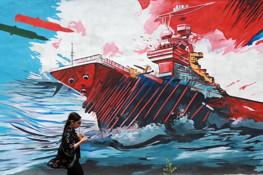 Una mujer iraní camina junto a un mural antiestadounidense en una calle de Teherán, Irán.