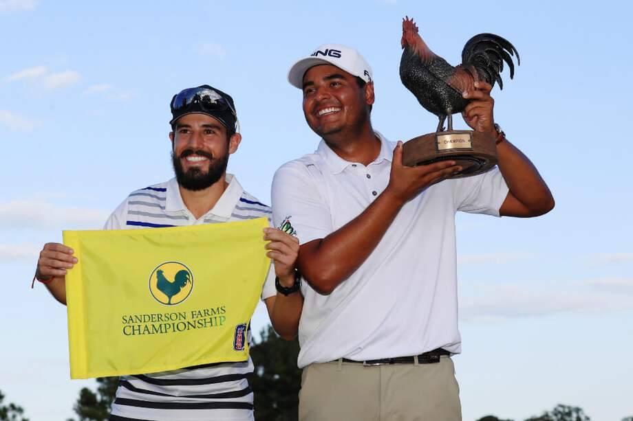 Juan Sebastián Muñoz junto a su caddie Mateo Gómez, celebran el título obtenido este domingo. / AFP