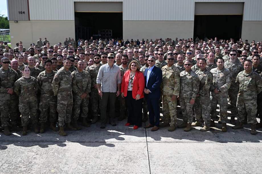 Fotografía de la gobernadora de Puerto Rico, Jenniffer González, y el secretario de Guerra de Estados Unidos, Pete Hegseth, posando con militares en la Base Aérea Muñiz.