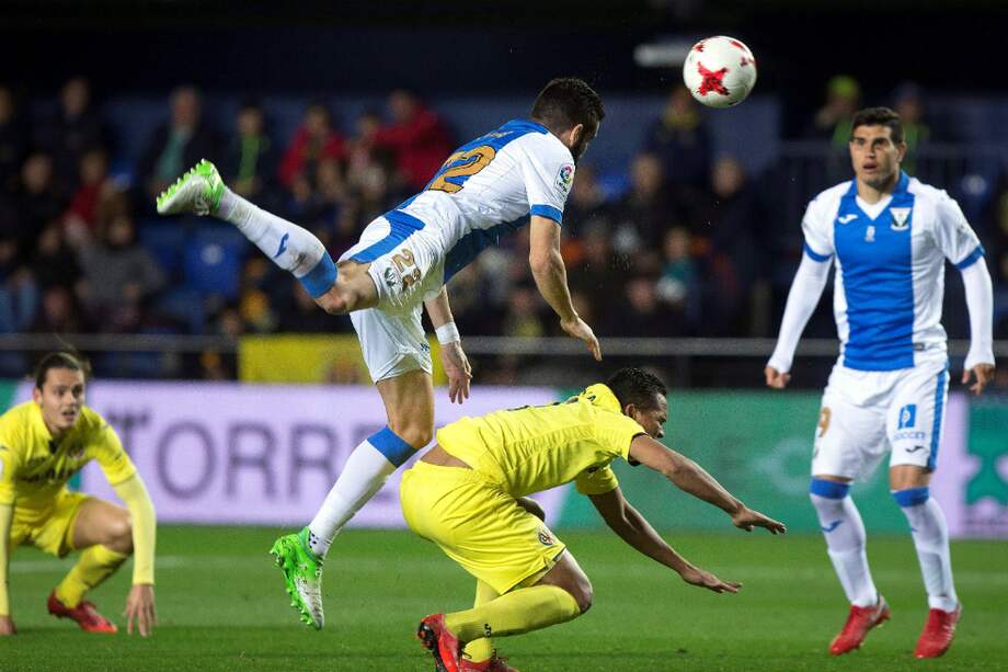 El delantero colombiano del Villarreal Carlos Bacca (en el suelo), pelea el balón con el defensa griego del Leganés, Dimitrios Siovas, durante el partido de vuelta de octavos de final de la Copa del Rey. / EFE