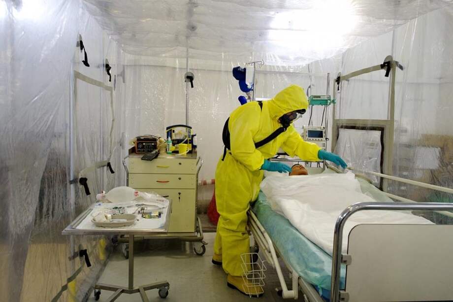 Personal militar viste con trajes especiales mientras trabajan en la simulación de un caso de enfermo de un virus contagioso en el centro de Defensa Biológica en Techonin cerca de Jablone Nad Orlici en República Checa.