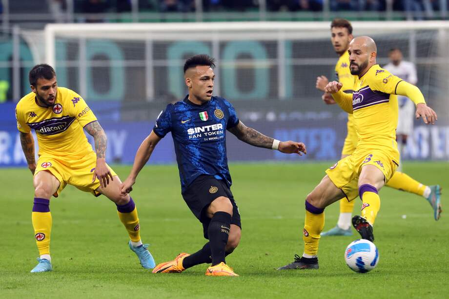 Lautaro Martinez, atacante de Inter, presionado por Lorenzo Venuti (izq.) y Riccardo Saponara, jugadores de Fiorentina.