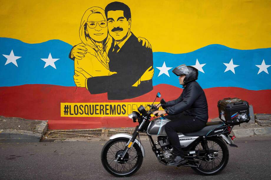 Una persona transita frente a un mural del presidente de Venezuela, Nicolás Maduro, y su esposa, Cilia Flores, este lunes, en Caracas (Venezuela).