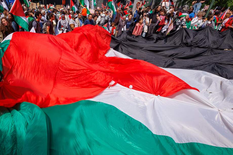 Manifestantes exhiben una bandera palestina durante una marcha por un alto al fuego en Gaza, en Bruselas, Bélgica.