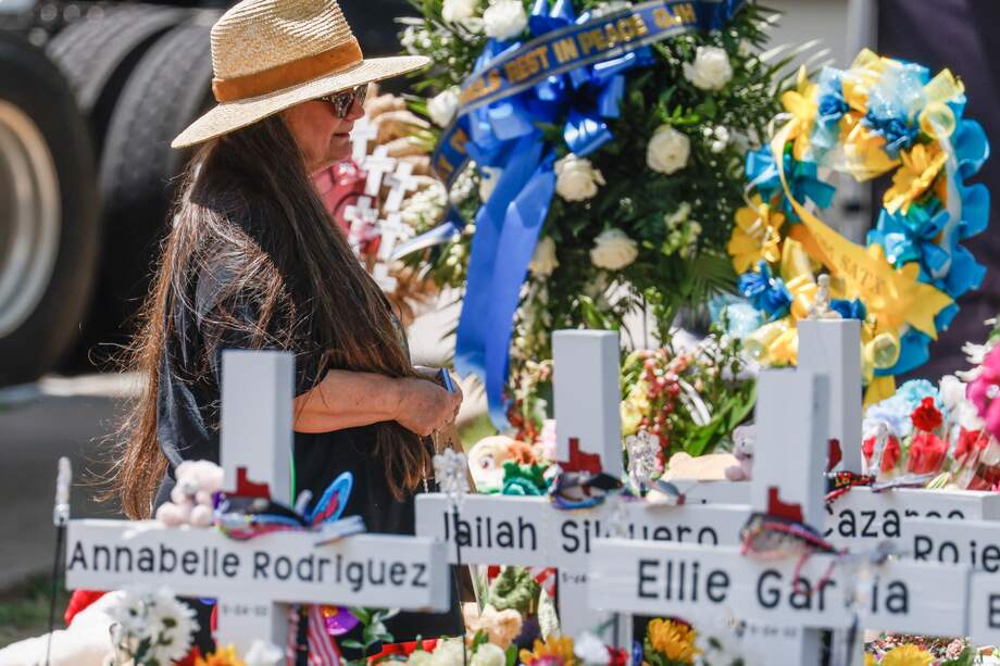 Una mujer se arrodilla entre los nombres de las víctimas tras el tiroteo masivo en la Escuela Primaria Robb en Uvalde, Texas, EE. UU.