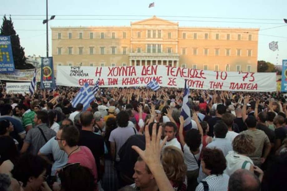 Ciudadanos alzan sus manos durante una protesta en la plaza Syntagma, frente al edificio del parlamento en Atenas, Grecia./ EFE