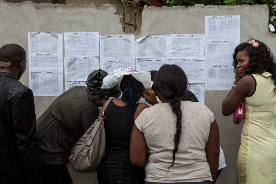 Voluntarios revisan los listados en Bayelsa, capital de Yenagoa antes de las elecciones presidenciales que se llevarán a cabo mañana en Nigeria. /AFP
