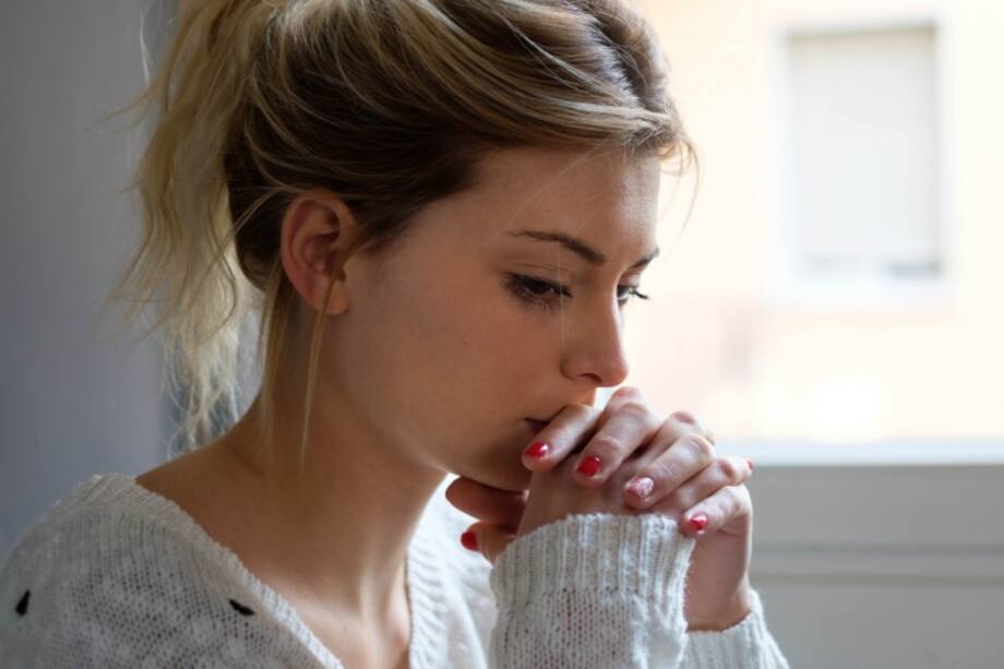 Mujer con las manos cruzadas en la boca
