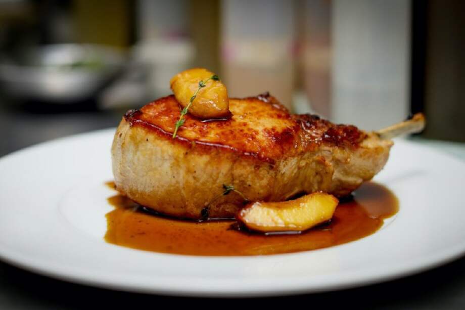 Chuletones de cerdo asados con manzanas en miel de tomillo. /Cortesía