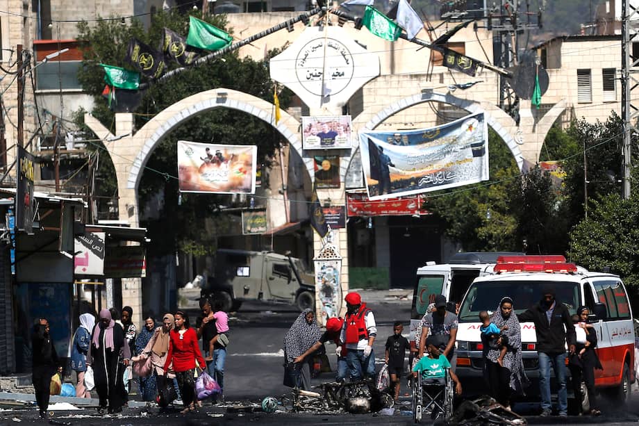 Miembros de la Sociedad de la Media Luna Roja Palestina ayudan a los refugiados a evacuar el campamento de Yenín, durante el segundo día de una operación militar israelí.