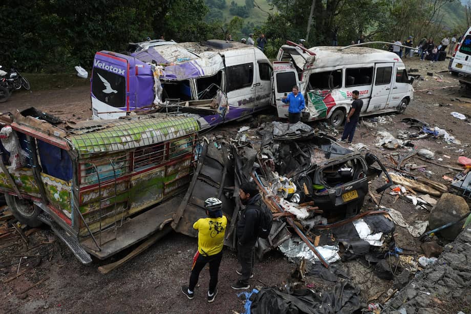 Personas observan este domingo vehículos destruidos por un atentado ocurrido en la Vía Panamericana en Cajibío. EFE/Ernesto Guzmán