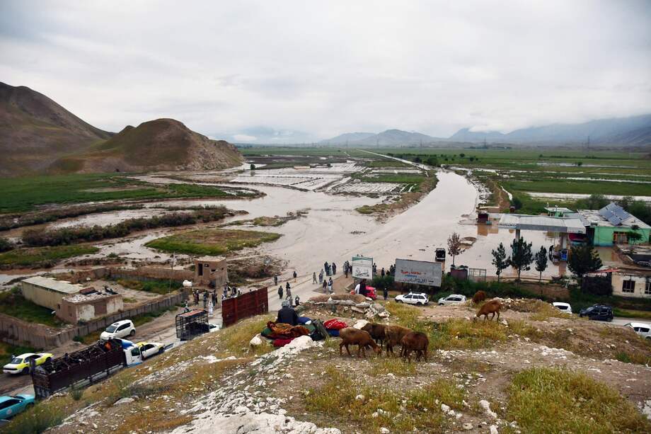Habitantes se reúnen a lo largo de una carretera en una zona inundada entre Samangán y Mazar-i-Sharif tras una inundación repentina tras unas fuertes lluvias en el distrito de Feroz Nakhchir de la provincia de Samangán el 11 de mayo de 2024.