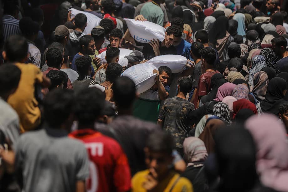 Palestinos desplazados esperan recibir ayuda del PMA tras su llegada exitosa a los almacenes de la organización en la ciudad de Gaza.