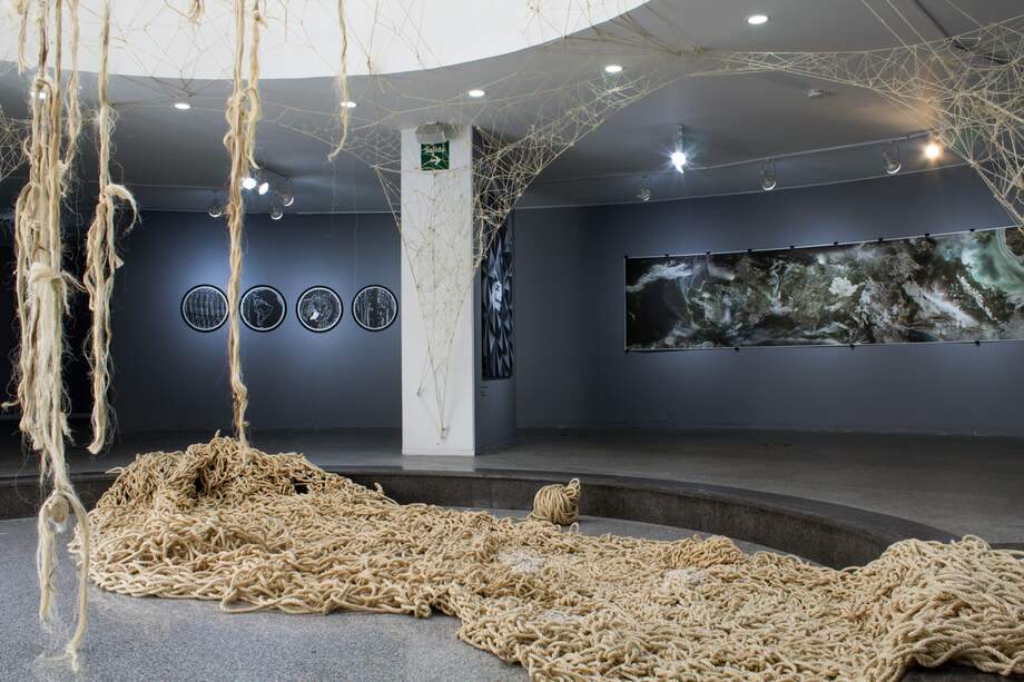 Obra en piso: Sin título (estructura de crecimiento aleatorio IX), Cristina Figueroa Palau, 2014. Instalación In situ, "Adaptación silenciosa", Ana Escobar, 2019-2021; al fondo izquierda: "Geo Bits - Globo Terráqueo 01,02,03,04". William Aparicio, 2012; al fondo derecha: "Orden natural II", Juan Cortés. Vista de la exposición Ciber Era, Museo de Arte Contemporáneo, MAC.