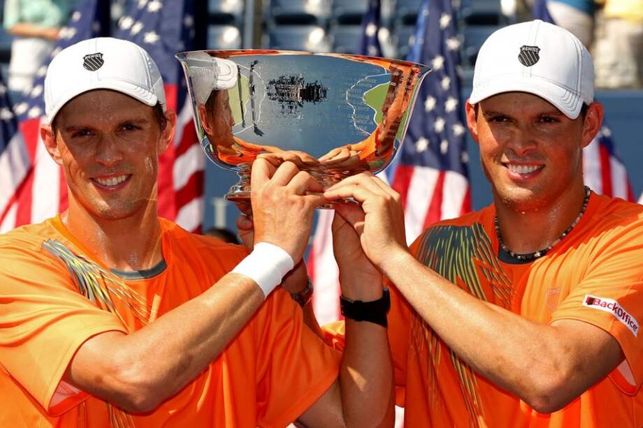 Los tenistas estadounidenses Bob Bryan (i) y Mike Bryan (2-i) con la copa de dobles del US Open. / EFE