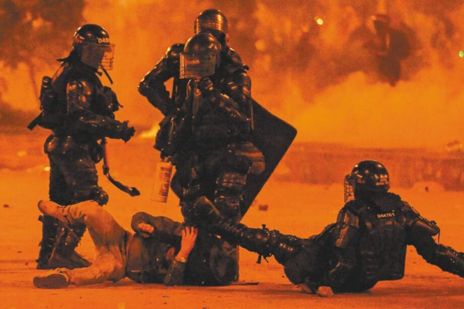 TOPSHOT - Riot police detain a demonstrator during a protest against the government of Colombian President Ivan Duque in Bogota on June 12, 2021. Dozens of people have been killed in protests that erupted around the country on April 28, initially against a tax hike that would have mostly affected the middle classes, but which have morphed into a major anti-government movement. / AFP / Juan BARRETO