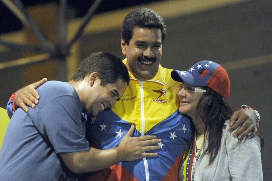 Nicolás Maduro Guerra abraza a su padre, Nicolás Maduro Moros, durante un acto de campaña en Caracas en 2013. / AFP