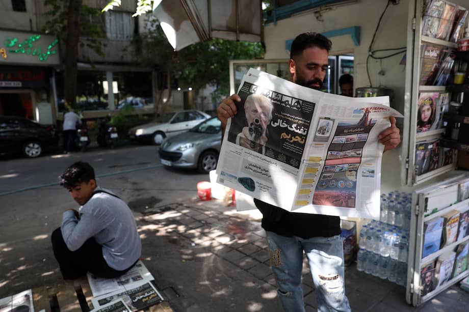 Un iraní lee un ejemplar de un diario que muestra una fotografía del presidente estadounidense, Donald Trump, con un titular en persa que dice: "El arma vacía de las sanciones".