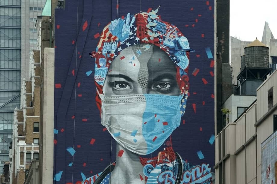 Un mural en honor a los trabajadores de la salud en el Centro Médico Montefiore en el Bronx, al lado de un edificio en Manhattan.
/ AFP