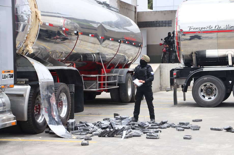 Un agente antidrogas de la Policía Nacional de Ecuador encuentra bloques de cocaína en un compartimento oculto de un camión en Tulcán (Ecuador).