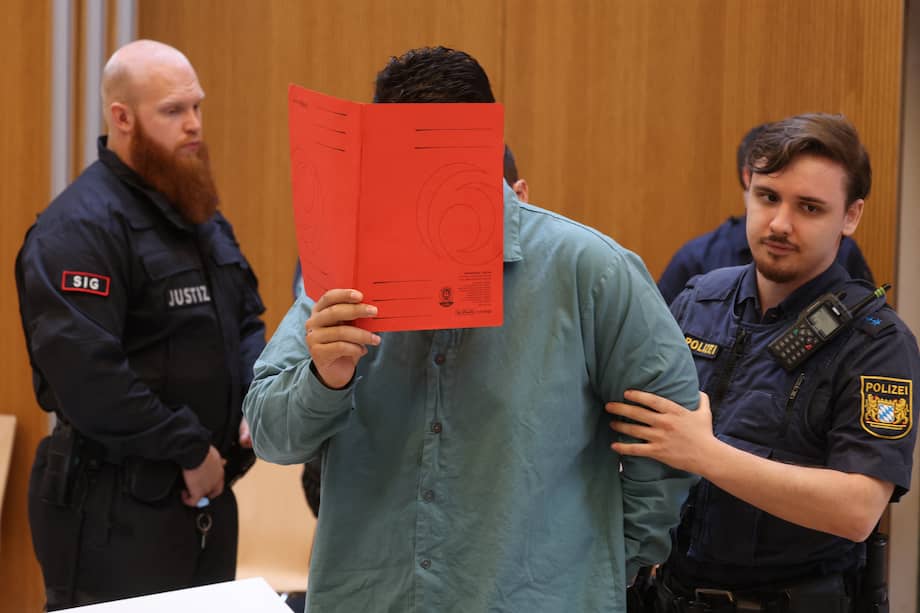 Farhad N., el afgano condenado a cadena perpetua por embestir con un vehículo una marcha sindical en Múnich en 2025, se cubre el rostro durante la lectura del veredicto en un tribunal de Alemania.